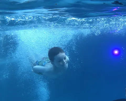 Underwater view of a swimmer in clear blue pool water